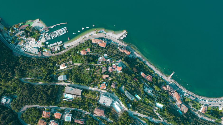 Stunning aerial view of Nago-Torbole's coastline, showcasing lush greenery and serene waters.
